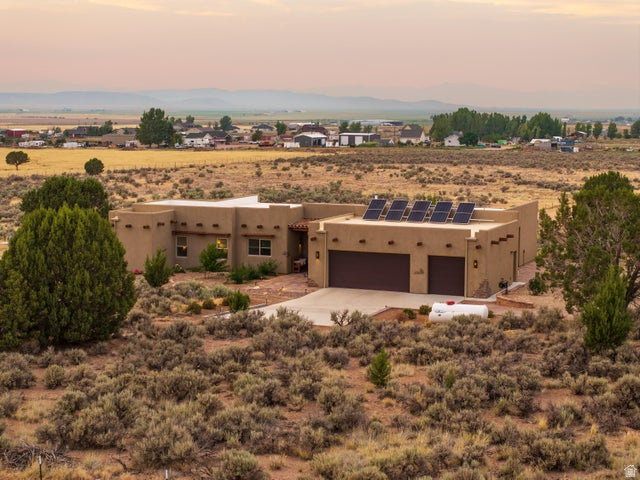 2925 Juniper Road Enterprise, UT 84725 - Photo 51 of 56 Southwest-style home featuring solar panels, stucco siding, view of desert landscape, and a view of rural / pastoral area