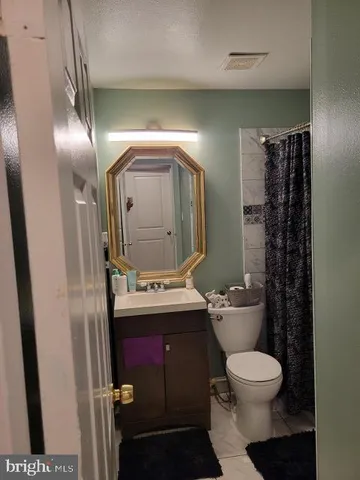 a bathroom with a toilet sink and mirror