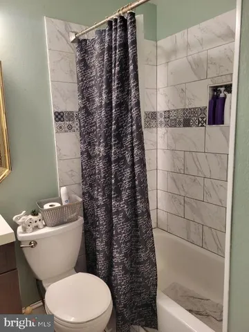 a white toilet sitting next to a bath tub