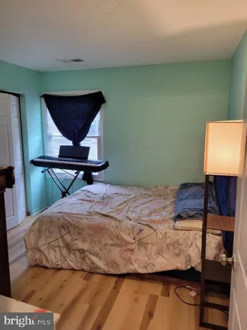 a bedroom with a bed wooden floor and window