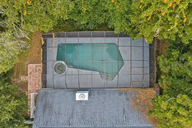 an aerial view of a house with a yard and large trees