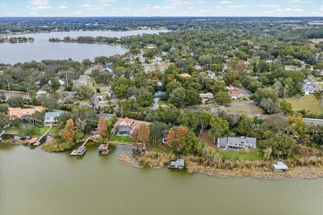 an aerial view of ocean and residential houses with outdoor space