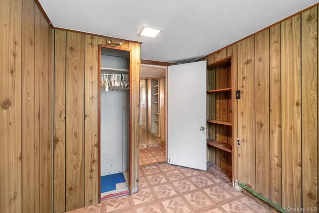a view of a hallway with wooden shelves