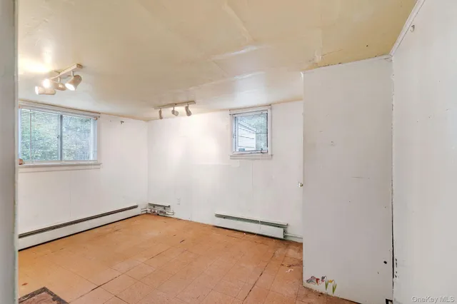 an empty room with windows and closet