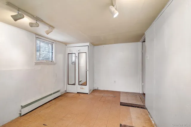 an empty room with windows and closet