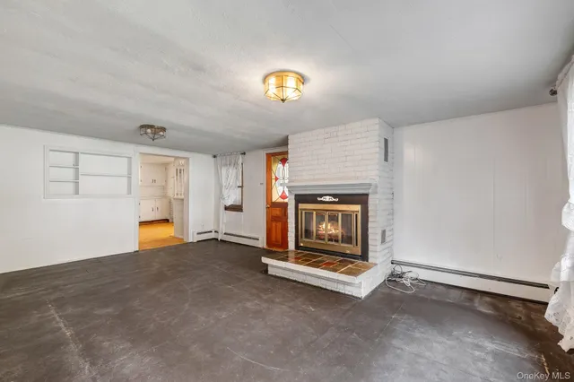 an empty room with a fireplace and window