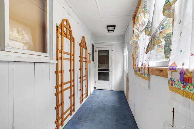 a view of a hallway with wooden floor and windows