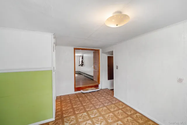 a view of a room with wooden floor and a bathroom