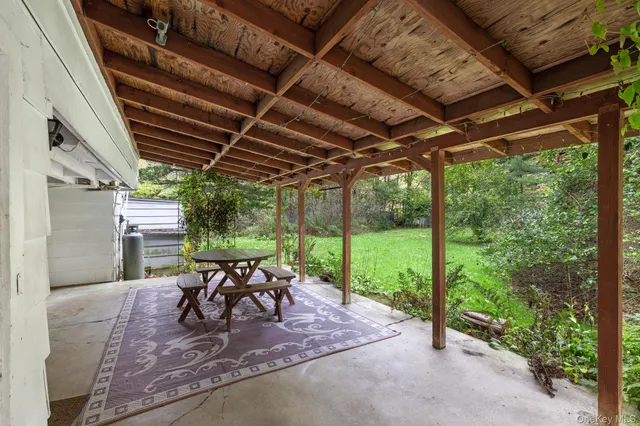 a view of a porch with furniture and a yard