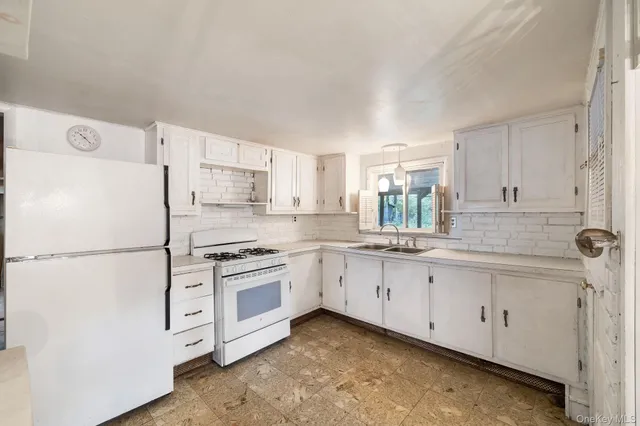a kitchen with granite countertop white cabinets and white appliances