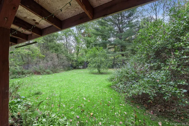 a view of a house with a big yard plants and large trees