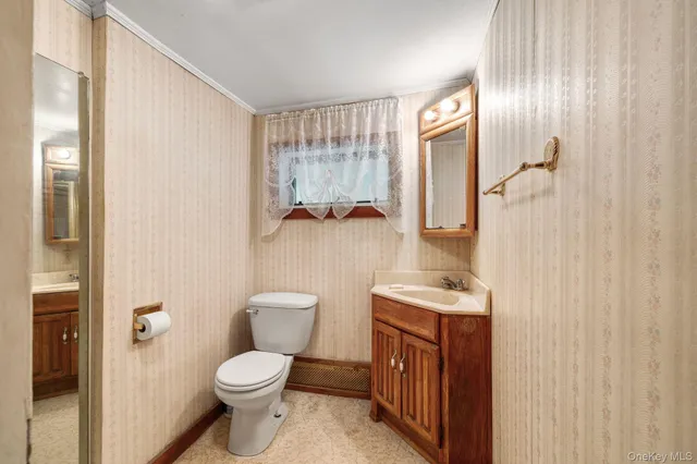 a bathroom with a granite countertop toilet sink and mirror