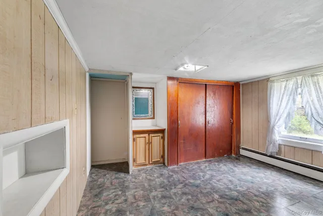 an empty room with windows and closet