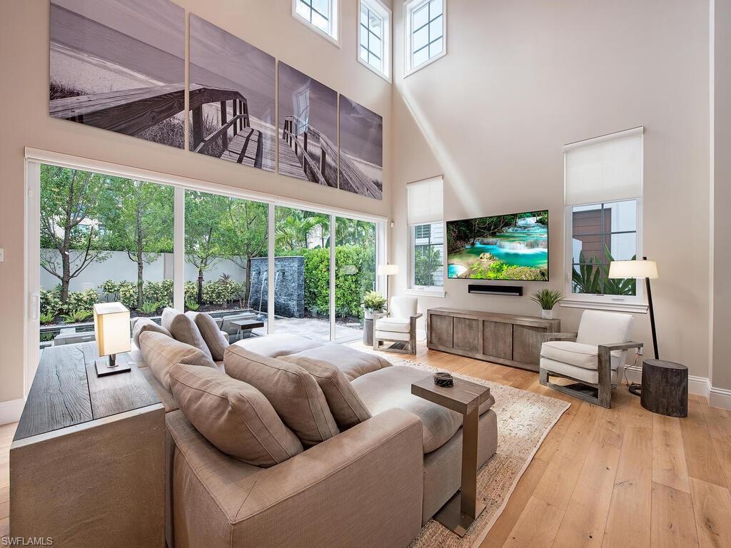 9200 Mercato Way Naples, FL 34108 - Photo 4 of 13 a living room with furniture a flat screen tv and a large window
