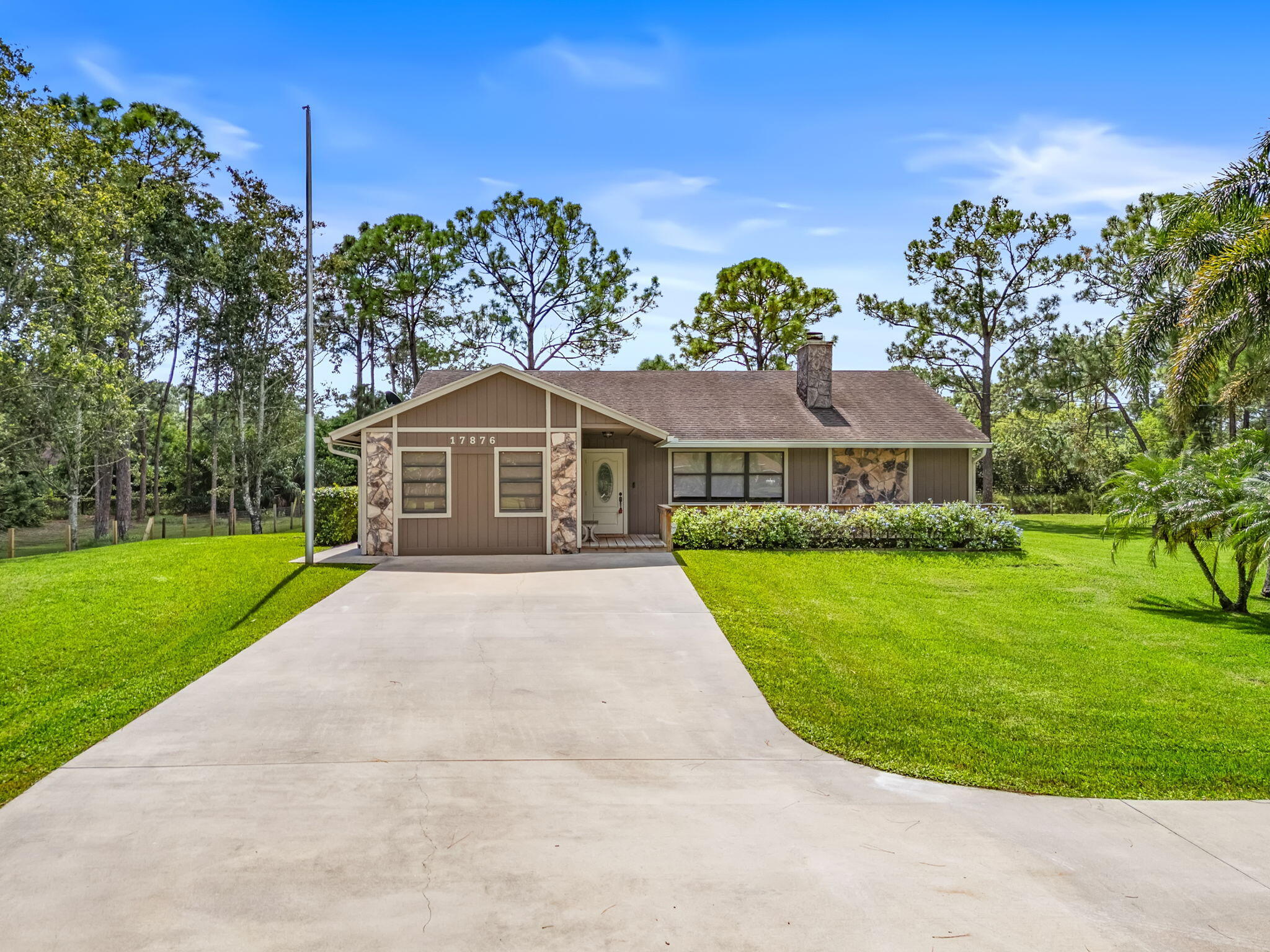 17876 43rd Road North Loxahatchee, FL 33470 - Photo 4 of 37 a front view of a house with a garden
