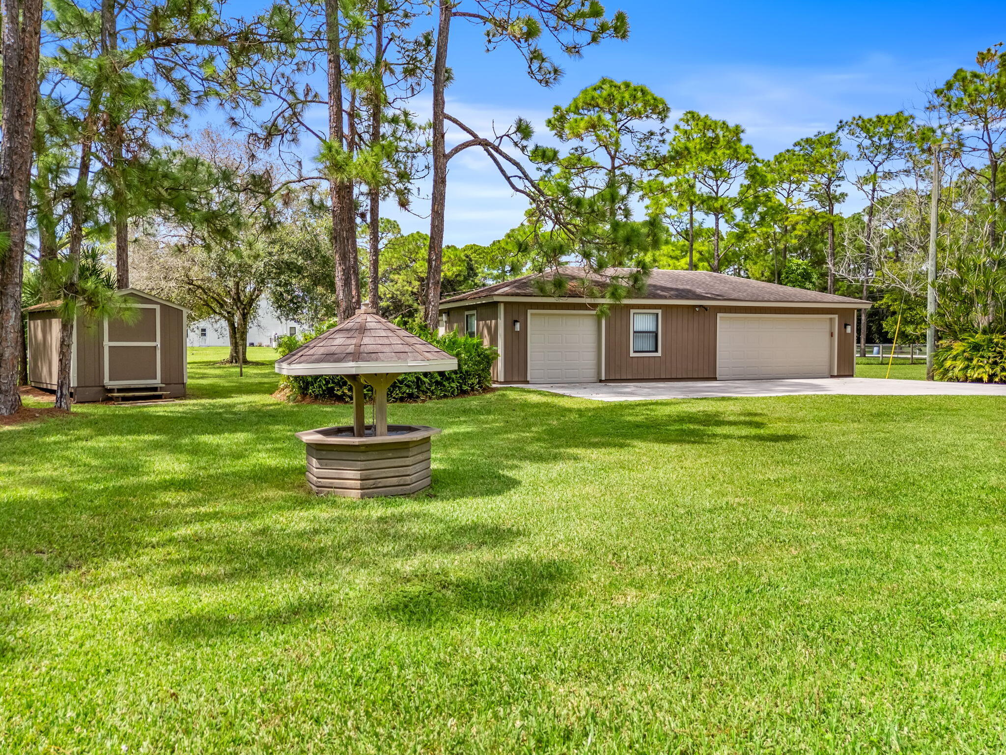 17876 43rd Road North Loxahatchee, FL 33470 - Photo 5 of 37 a front view of a house with a garden and trees