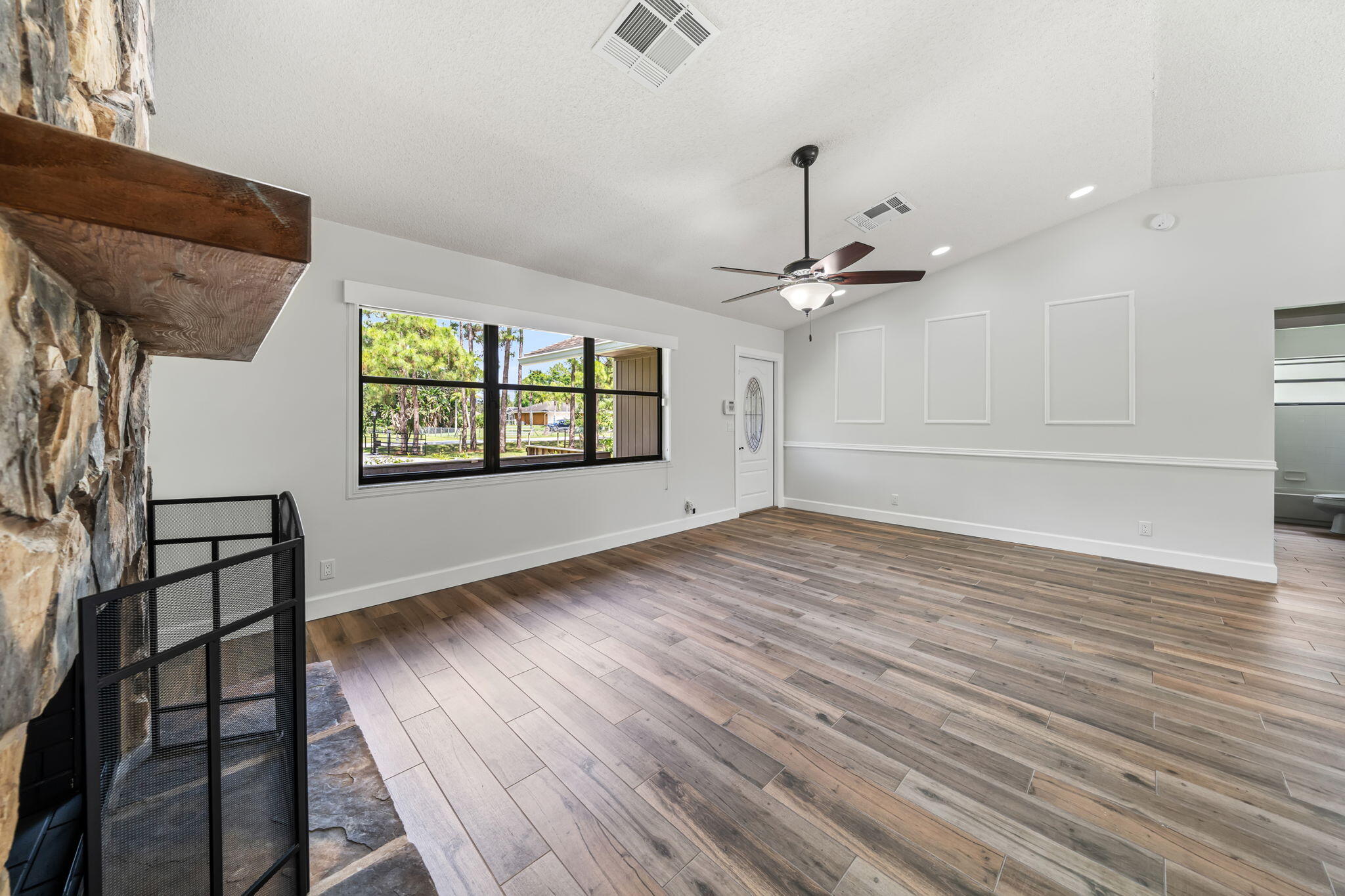 17876 43rd Road North Loxahatchee, FL 33470 - Photo 10 of 37 an empty room with wooden floor fan and windows