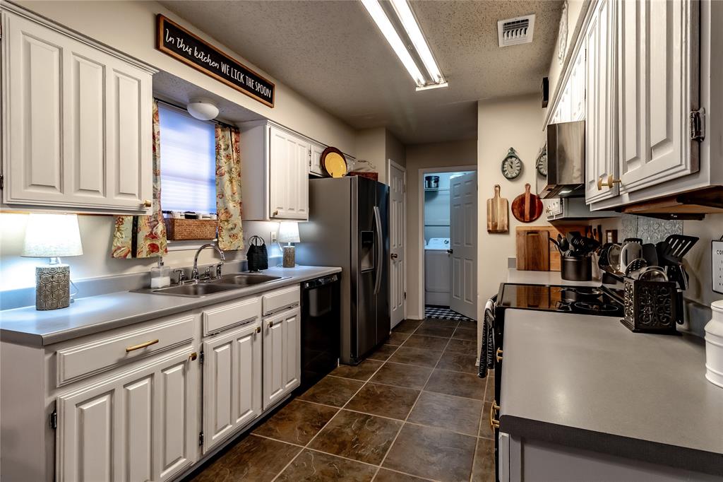 266 East Ridgegate Drive Garland, TX 75040 - Photo 2 of 32 a kitchen with stainless steel appliances a sink stove and cabinets