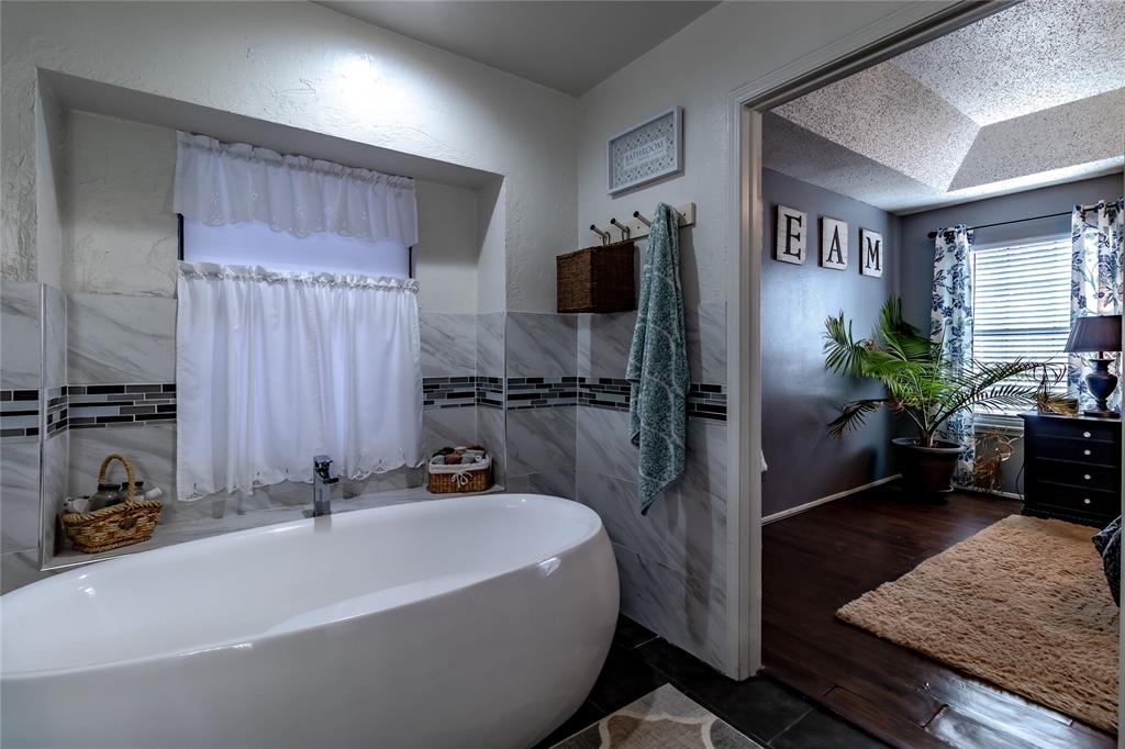 266 East Ridgegate Drive Garland, TX 75040 - Photo 24 of 32 a bathroom with a tub a potted plant and a sink