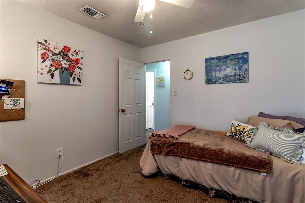 266 East Ridgegate Drive Garland, TX 75040 - Photo 26 of 32 a bedroom with a bed and a chandelier