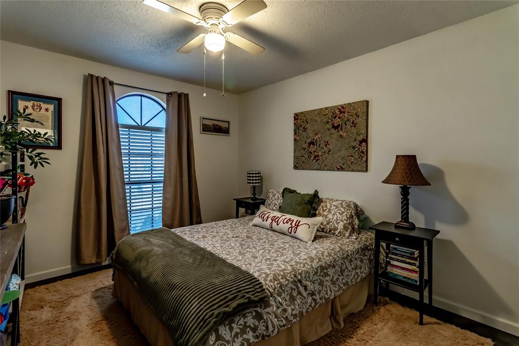 266 East Ridgegate Drive Garland, TX 75040 - Photo 29 of 32 a bedroom with a bed and a chandelier