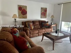 a living room with furniture a rug and a window