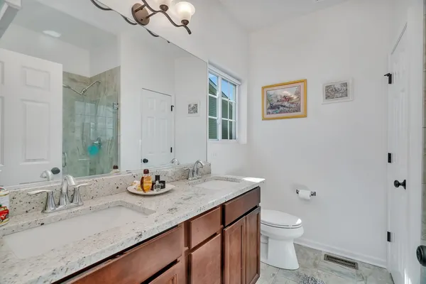 a bathroom with a granite countertop sink a toilet and a mirror