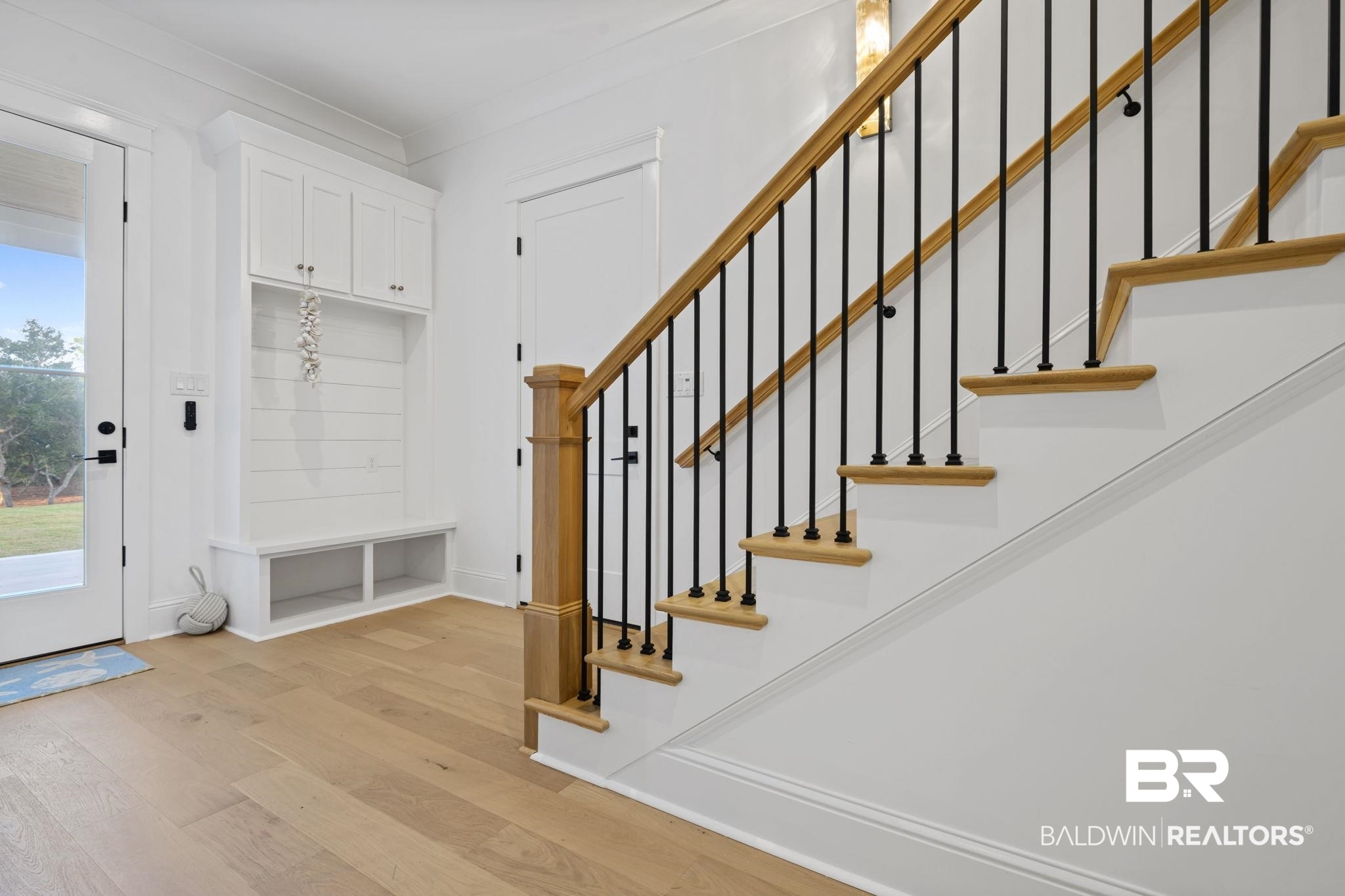 30313 River Road Orange Beach, AL 36561 - Photo 29 of 50 Foyer entrance with wood finished floors, stairs, and ornamental molding