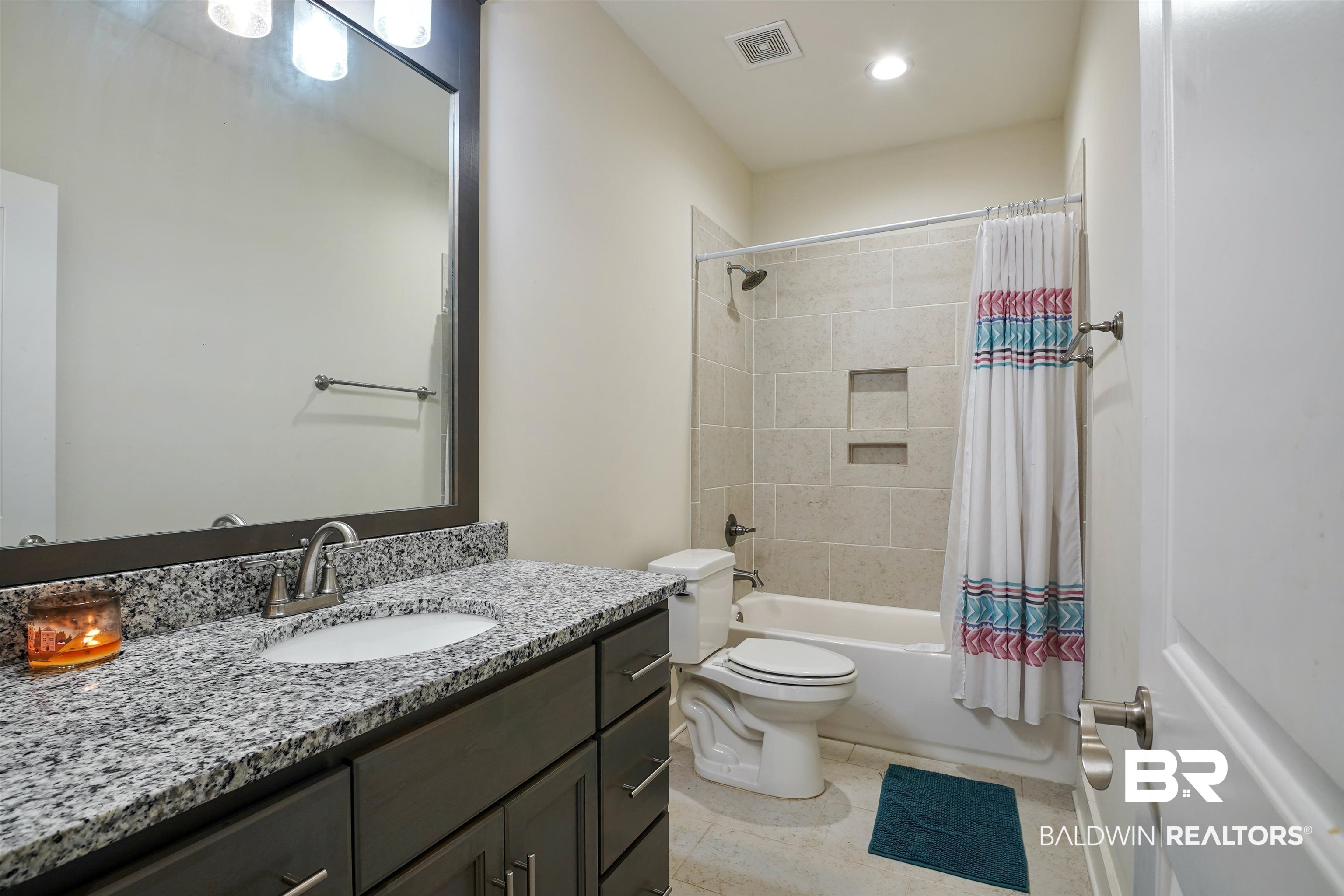 7090 Rocky Rd Loop Gulf Shores, AL 36542 - Photo 18 of 34 Full bath featuring vanity, visible vents, shower / bath combo with shower curtain, tile patterned floors, and toilet