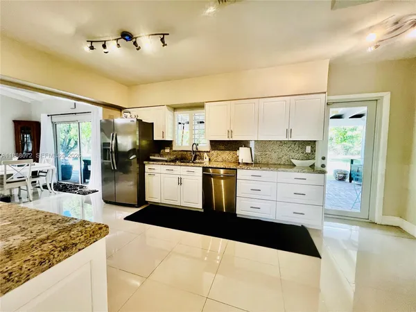 a kitchen with stainless steel appliances kitchen island granite countertop a sink and cabinets