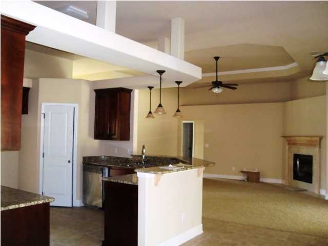 3056 Wallace Lake Road Pace, FL 32571 - Photo 11 of 19 a living room with stainless steel appliances kitchen island granite countertop furniture and a fireplace