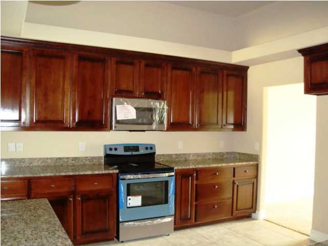 3056 Wallace Lake Road Pace, FL 32571 - Photo 12 of 19 a kitchen with granite countertop wooden cabinets and a stove top oven