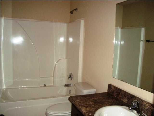 3056 Wallace Lake Road Pace, FL 32571 - Photo 16 of 19 a bathroom with a granite countertop bathtub sink vanity mirror and toilet