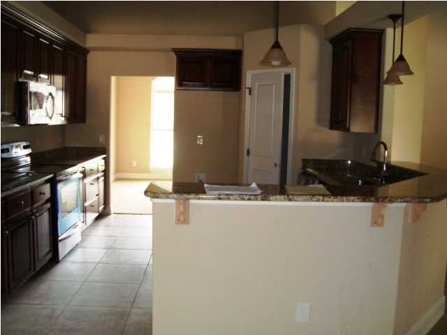 3056 Wallace Lake Road Pace, FL 32571 - Photo 4 of 19 a kitchen with stainless steel appliances granite countertop a sink and a stove