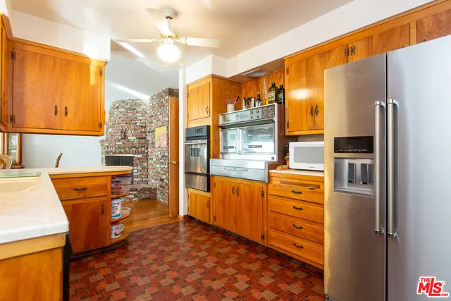 a kitchen with stainless steel appliances granite countertop a sink stove and wooden cabinets