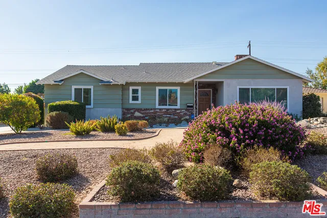 a front view of house with yard and trees around