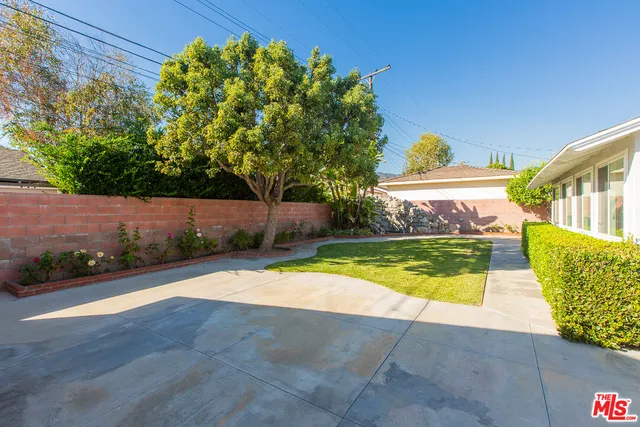 a front view of a house with a yard and potted plants