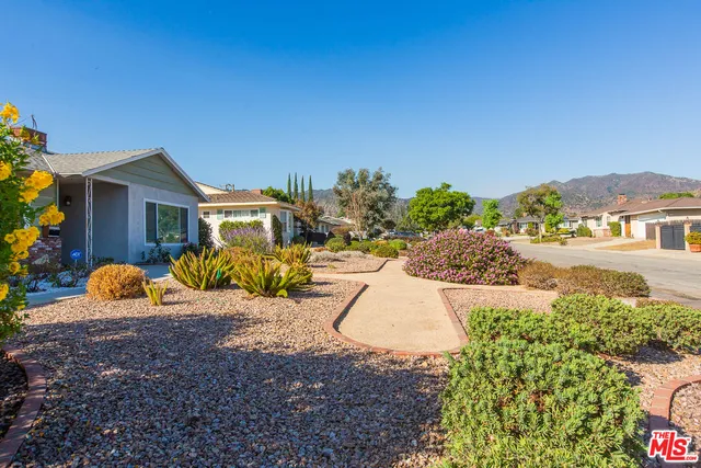 a view of a house with backyard and sitting area