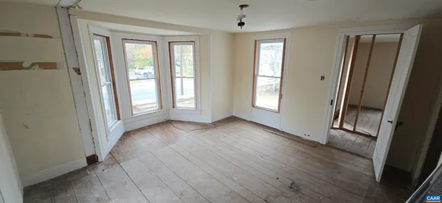an empty room with windows and closet