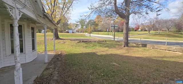 a view of a house with a yard and tree