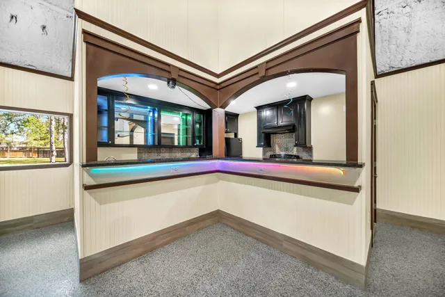 a view of a hallway with wooden floor and a flat screen tv