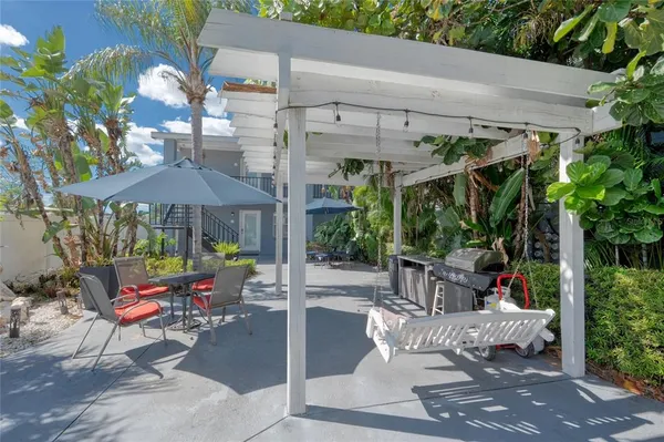 a view of a patio with table and chairs under an umbrella