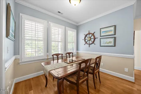 a view of a a dining room with furniture window and wooden floor