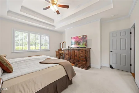 a bedroom with a bed and a flat tv screen on dresser