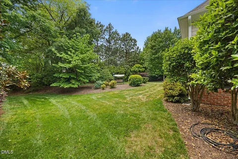 a view of a backyard with table and chairs plants
