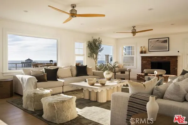 a living room with furniture a large window and a fireplace
