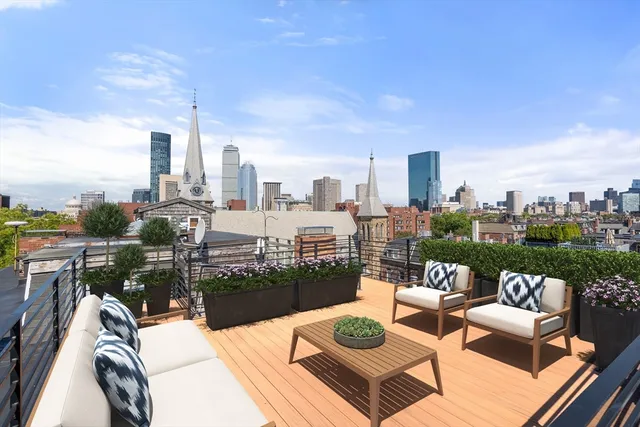 a view of a roof deck with couches and potted plants