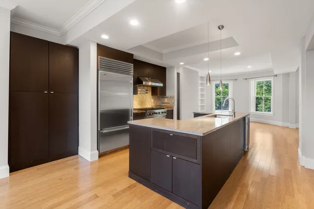 a large kitchen with stainless steel appliances granite countertop a large counter top and wooden floors