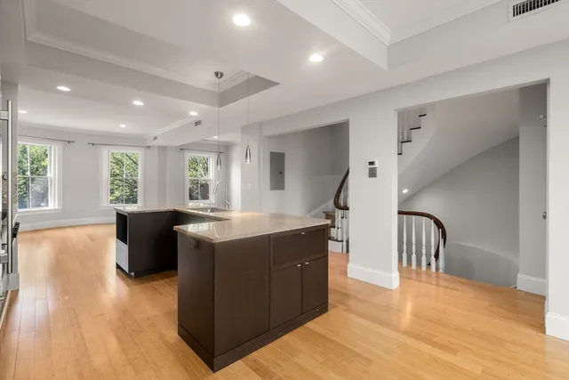 a kitchen with a wooden floor and windows