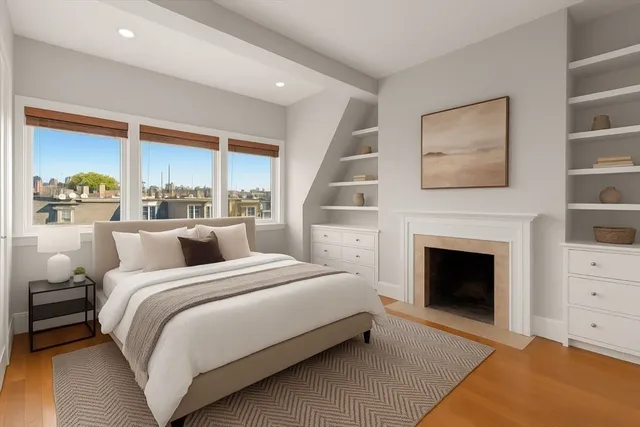 a large white bed sitting in a bedroom next to a window